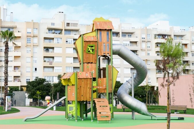 Public playgrounds - eibe play equipment with slide in front of a residential complex.