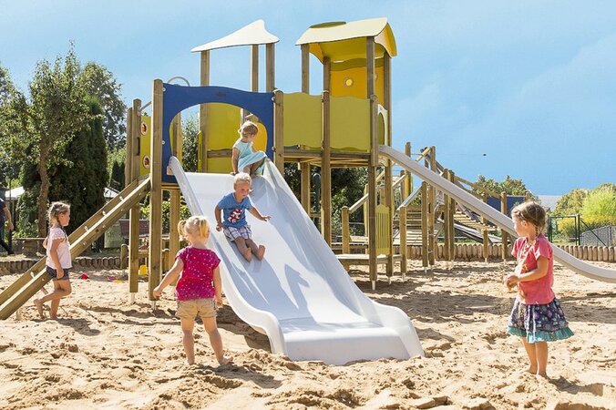 aire de jeux colorée avec des enfants sur une grande surface de sable.