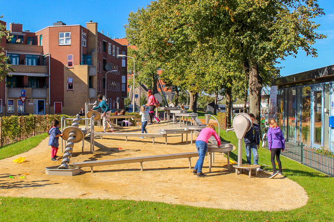 Playgrounds for housing estates - children playing on a water playground in front of a residential building.